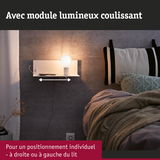 Étagère murale blanche avec module lumineux coulissant au-dessus d'un lit avec mur gris et couverture en tricot