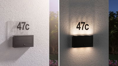 Applique LED noire pour numéro de maison avec plexiglas et panneau solaire, numéro 47c éclairé sur mur blanc