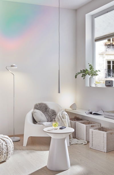 Moderne woonkamer met witte kunststofstoel, bijzettafel en zilveren vloerlamp voor sfeervolle verlichting
