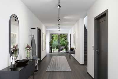 Moderne gang med sort LED-skinnebelysning, gråt gulv og minimalistiske møbler.