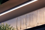 Lumière LED blanche sous meuble au-dessus de verres sur étagère en bois pour éclairage cuisine