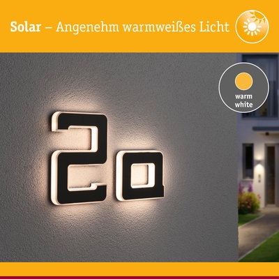 Solar beleuchtete Hausnummer 2a in Schwarz mit warmweißem Licht an grauer Wand