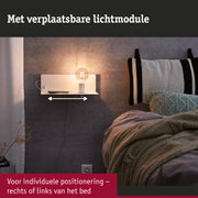 Witte wandlamp met verstelbare lichtmodule naast bed met grijs gebreid kussen