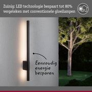 Zwarte LED-wandlamp op grijze muur met energiezuinige verlichting en boom op de achtergrond