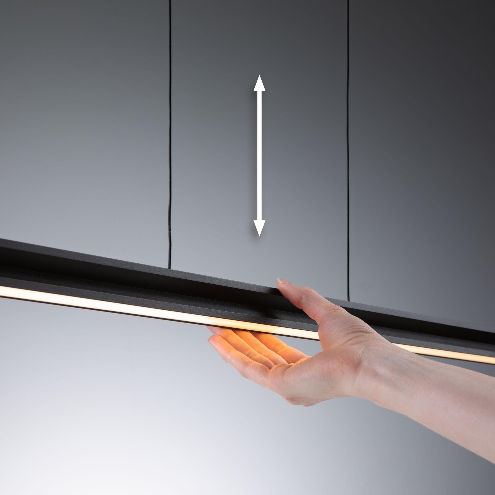 Main tenant un éclairage LED noir avec lumière blanche chaude sur fond gris, éclairage moderne
