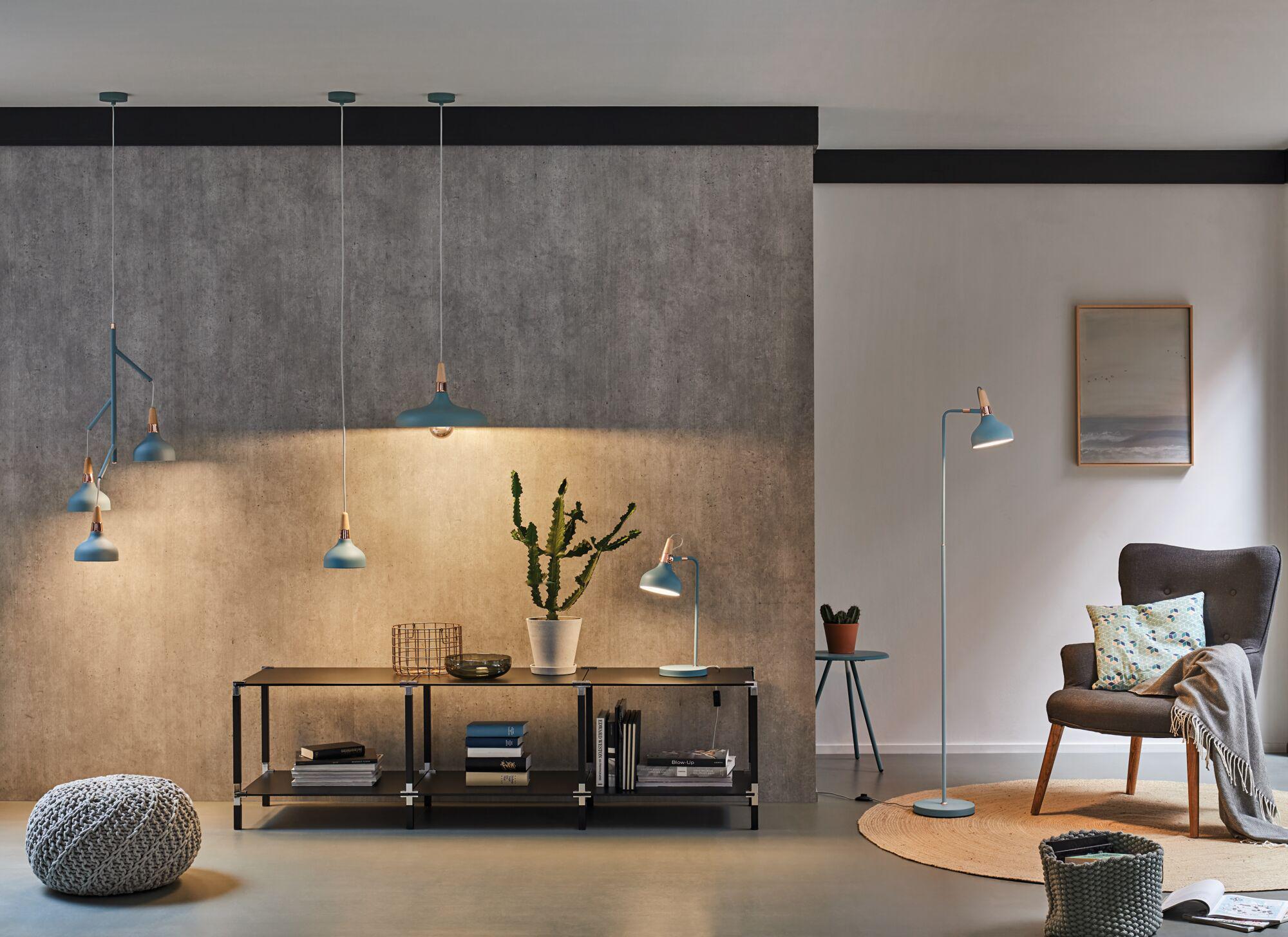 Modern blue metal pendant and floor lamps in living room with grey wall and furniture