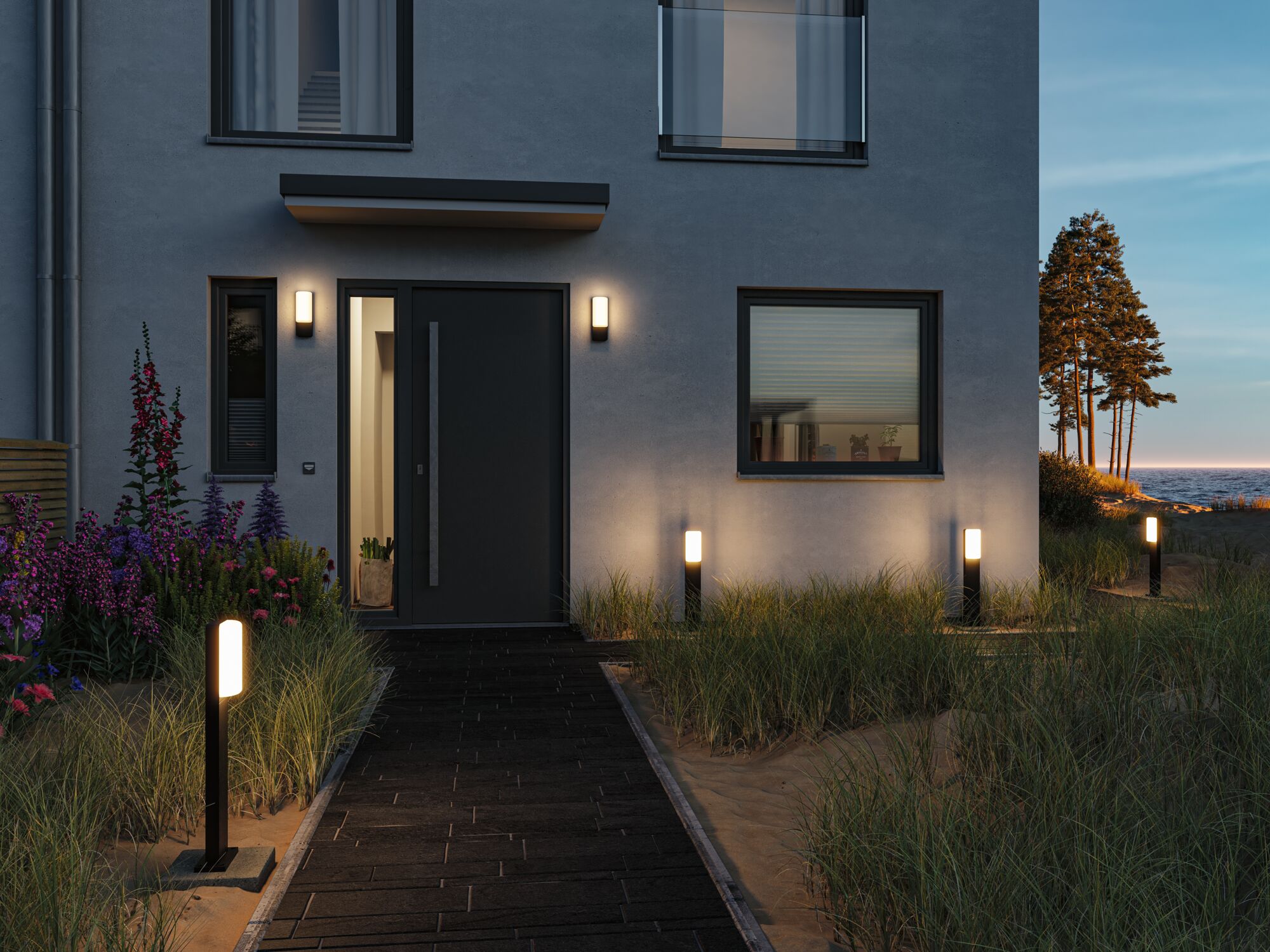 Moderne Außenbeleuchtung mit schwarzen LED-Wegeleuchten und Wandlampen an Hausfassade bei Dämmerung