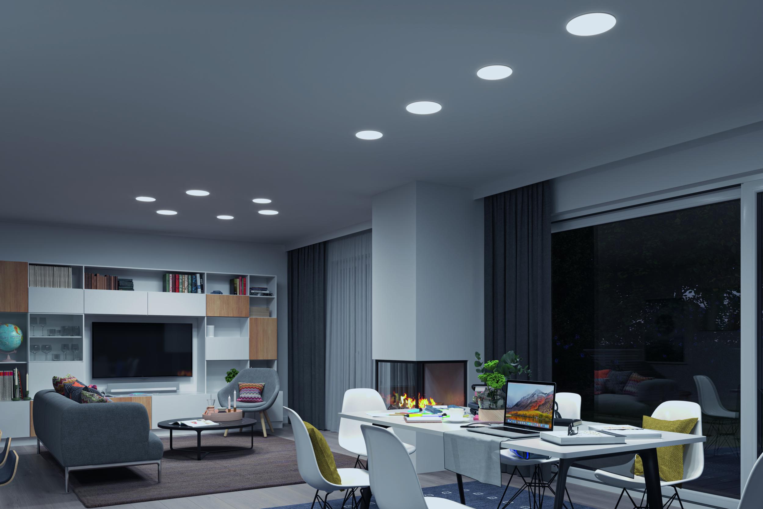 Modernes Wohnzimmer mit weißen LED-Einbaustrahlern, grauem Sofa und Kamin für gemütliche Beleuchtung.