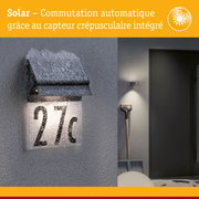 Applique solaire noire avec capteur crépusculaire intégrée éclairant le numéro de maison 27c enneigé