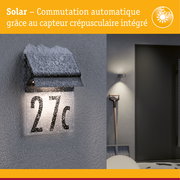 Applique solaire noire avec capteur crépusculaire intégrée éclairant le numéro de maison 27c enneigé