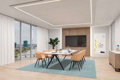 Salle de réunion moderne avec table blanche rectangulaire, chaises beiges et éclairage LED au plafond