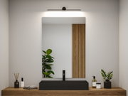 Schwarze LED-Spiegelleuchte über rechteckigem schwarzen Waschbecken auf Holzplatte im modernen Bad