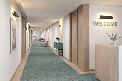 Moderner Flur mit Holzdekor und grünen Teppichboden, beleuchtet von schwarzen Wandlampen für Innenbeleuchtung.