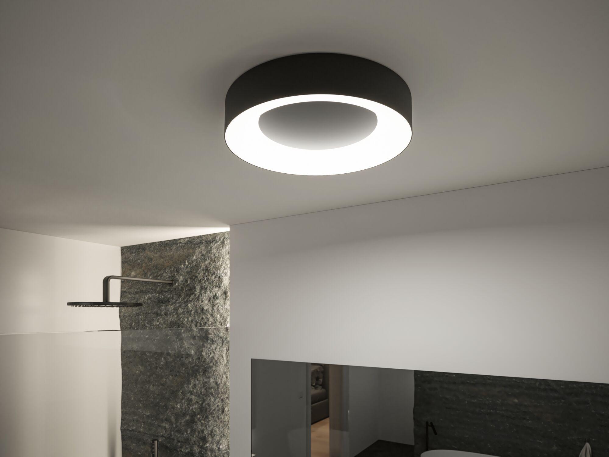 Rund sort loftlampe med lys LED-ring i moderne badeværelse med bruser og spejl