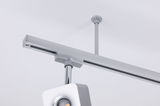 Modern silver metal LED track spotlight mounted on white ceiling for adjustable lighting