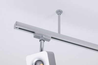 Moderner silberner LED-Schienenstrahler aus Metall an weißer Decke für flexible Beleuchtung