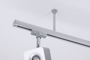 Moderner silberner LED-Schienenstrahler aus Metall an weißer Decke für flexible Beleuchtung