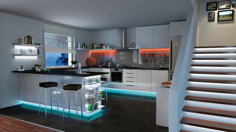 Moderne weiße Küche mit LED-Unterbau- und Treppenbeleuchtung in Blau und warmem Orange, LED Downlights.