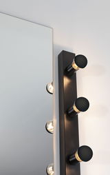 Schwarze Wandlampe mit drei runden Glühbirnen neben Spiegel, modernes LED-Wandlicht für Badezimmer.