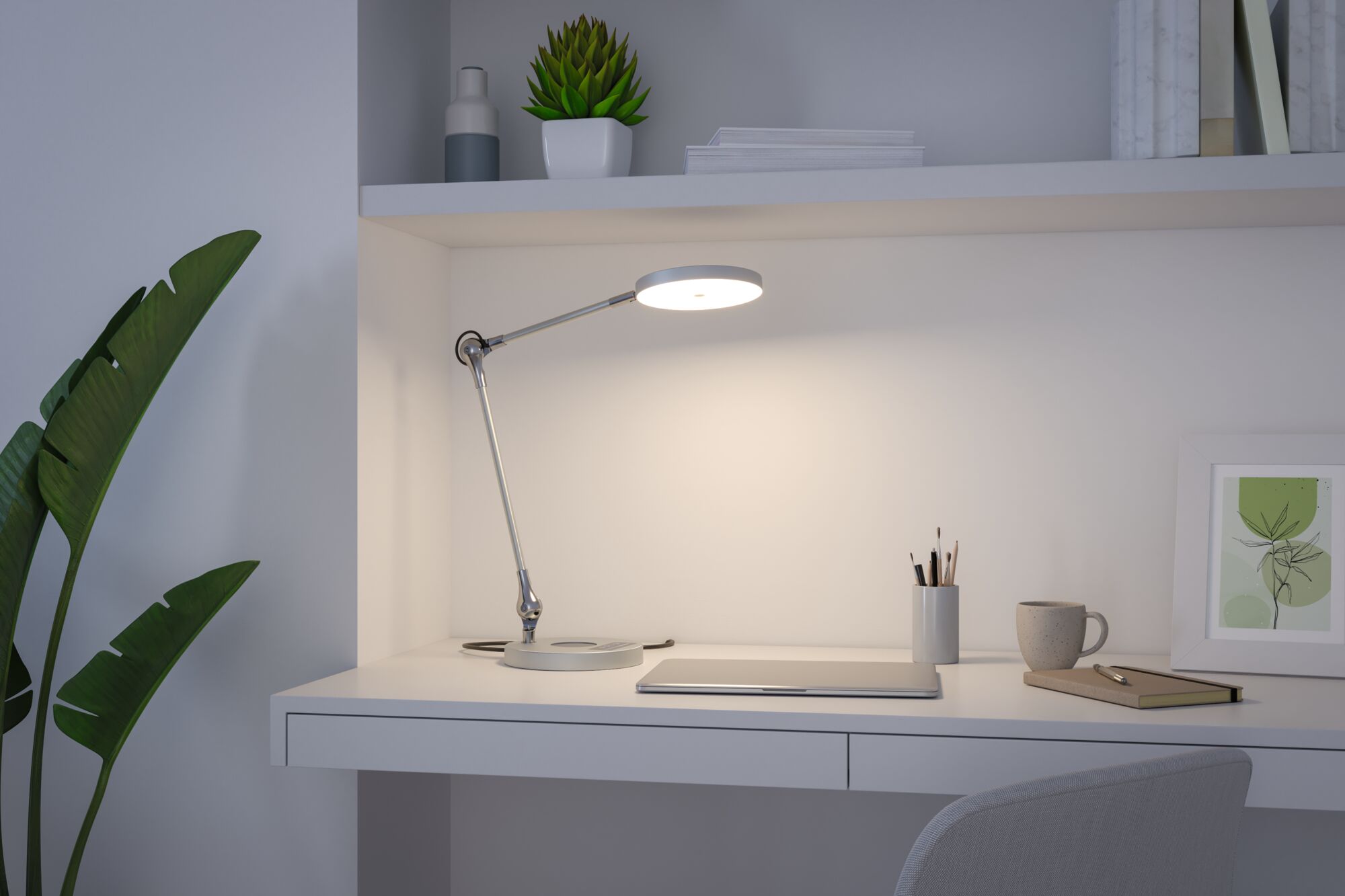 Moderne weiße Schreibtischlampe aus Metall mit rundem Leuchtkopf auf minimalistischem Arbeitsplatz.