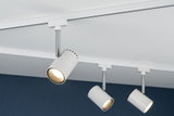 Three white metal LED spotlights on track system against dark blue wall for accent lighting