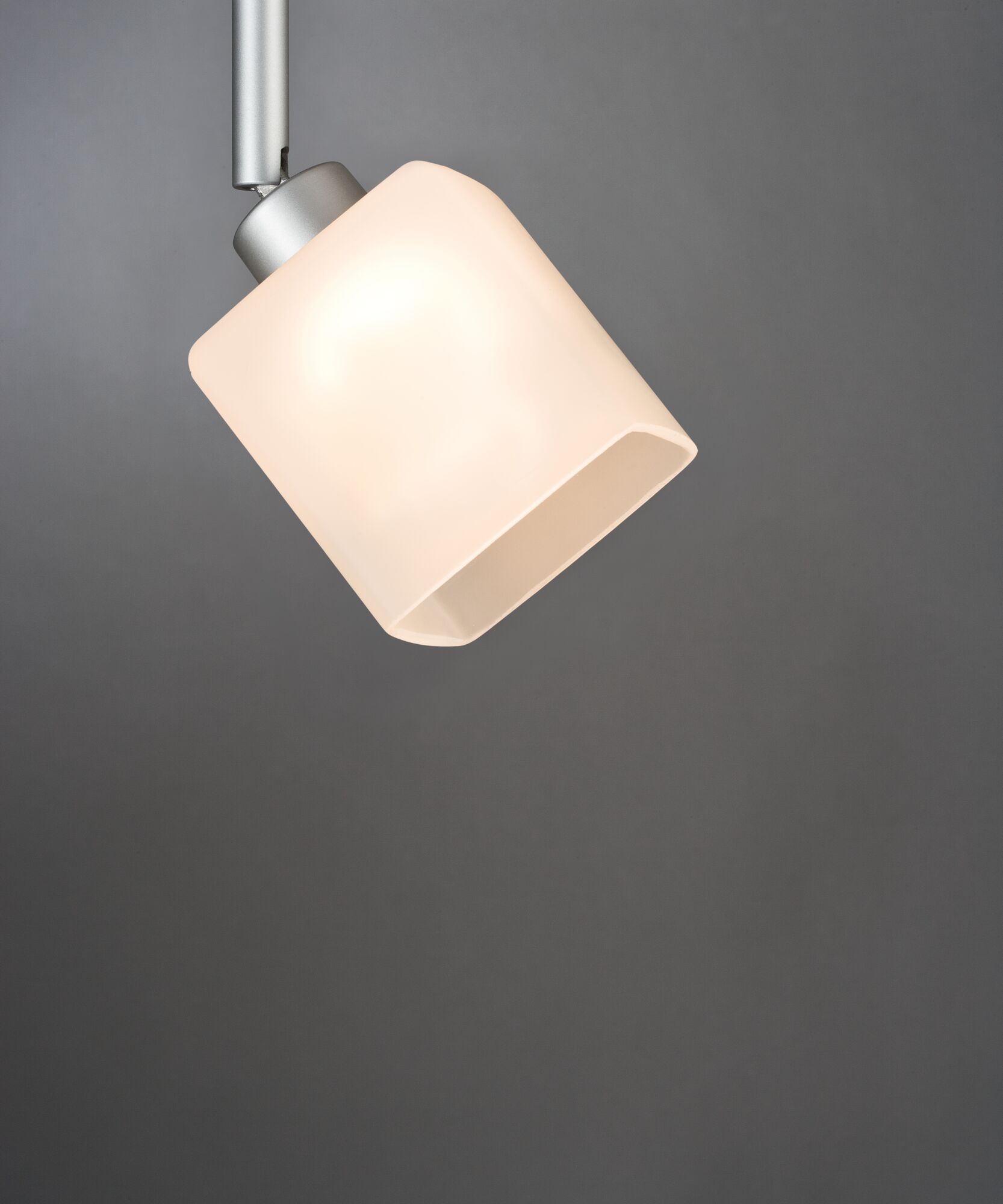 Modern ceiling spotlight with matte white glass shade and silver metal arm for living spaces.