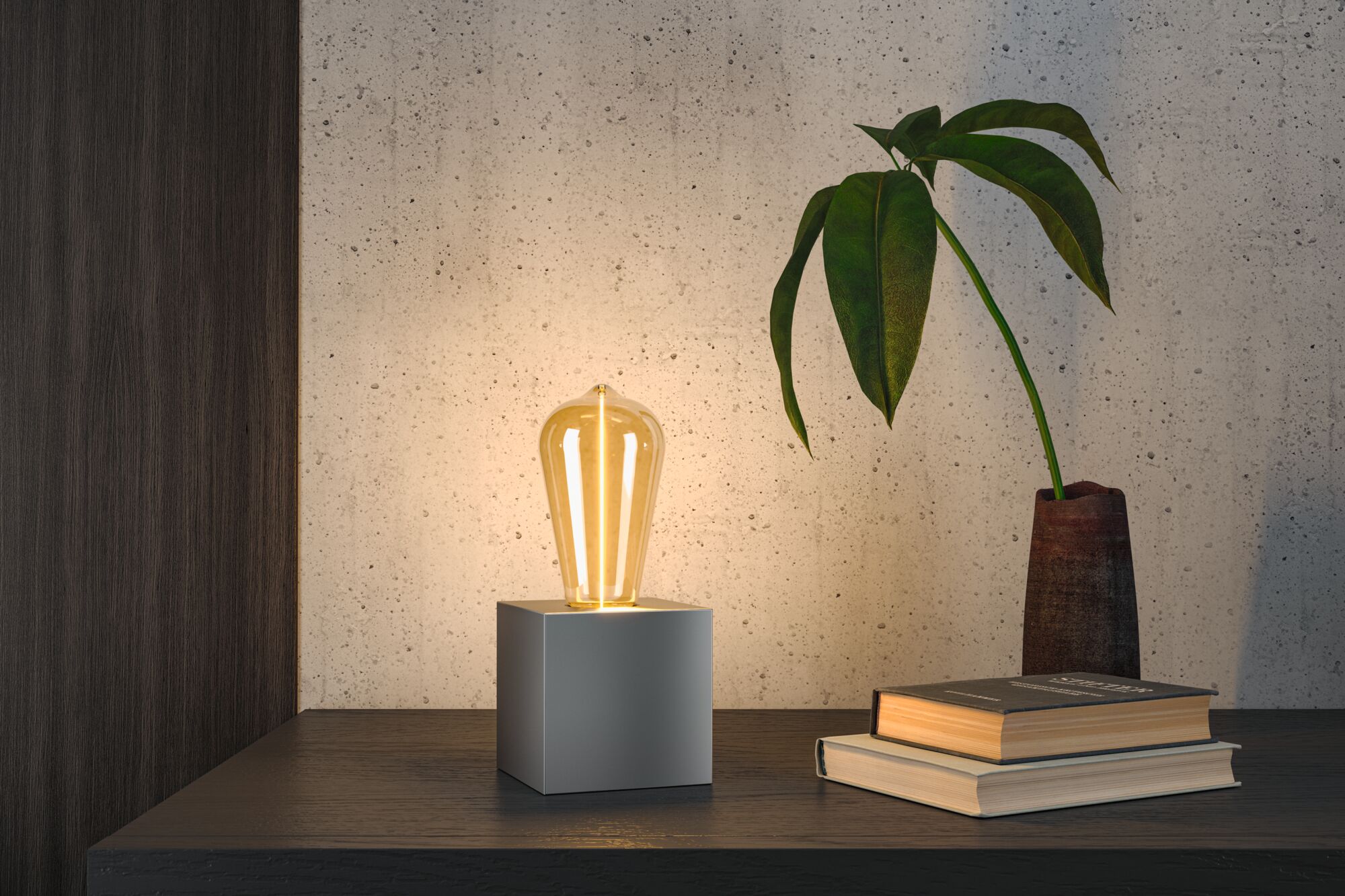 Moderne Tischleuchte mit warmweißem LED-Leuchtmittel auf grauem Würfel aus Metall für Wohnräume