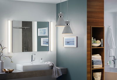 Moderne badkamer met witte wastafel, grijs betonnen aanrecht en twee grijze betonnen hanglampen.