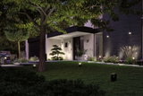 Moderne buitenverlichting met zwarte LED-spotlights die tuinpad en huisgevel 's nachts verlichten