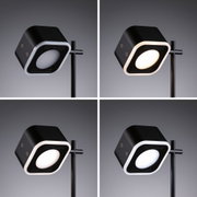Black LED floor lamp with square head and adjustable light colors for modern interior lighting.