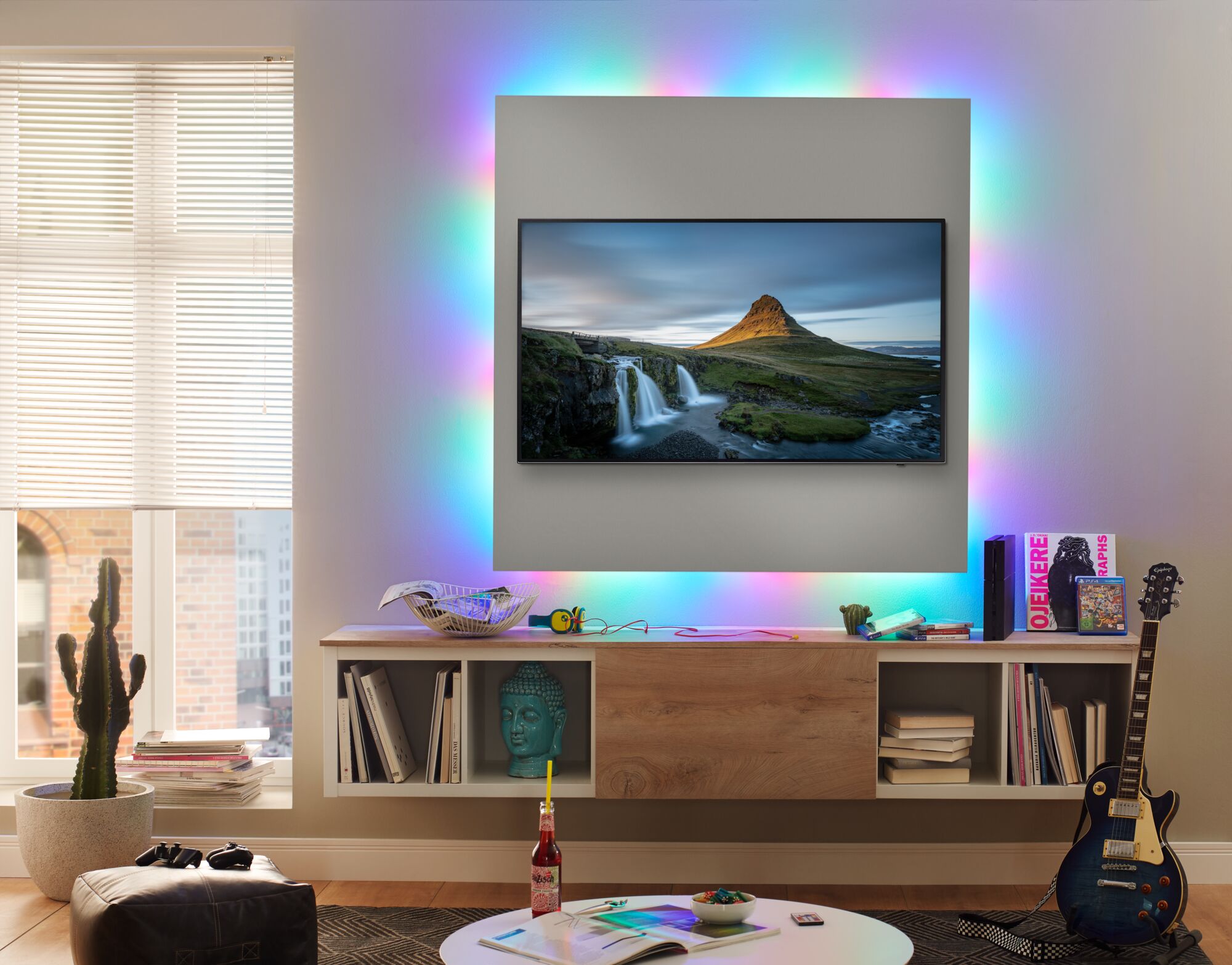 Wohnzimmer mit TV und buntem LED-Hintergrundlicht für moderne Ambientebeleuchtung und Smart Home Lichtsteuerung