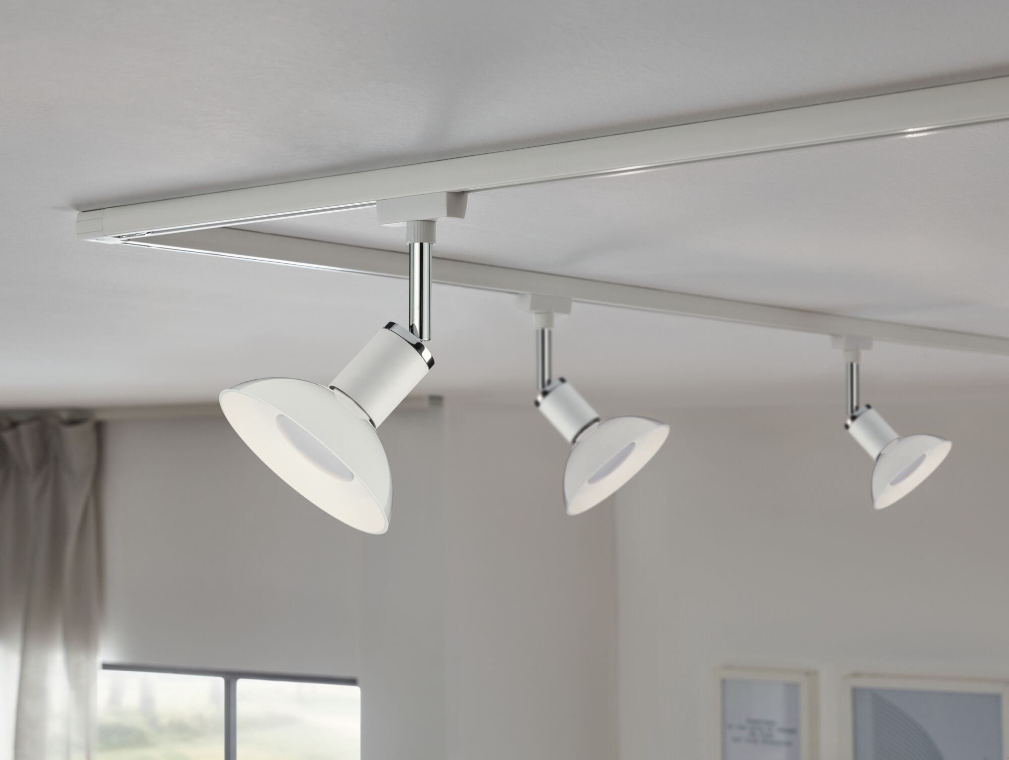 Tre hvide LED-loftspots i metal på skinnesystem til moderne rumlys