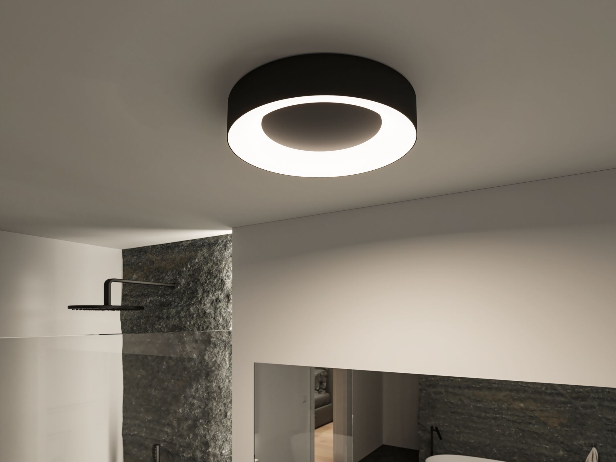 Round black ceiling light with warm white LED ring in modern bathroom featuring stone wall.