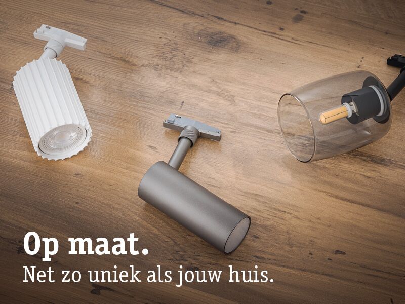 Drie verschillende moderne LED-railspots in wit, grijs en glas op houten ondergrond voor maatwerkverlichting.