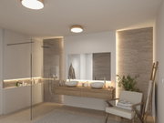 Modern bathroom with wooden vanity, two white vessel sinks, and warm white wooden ceiling light fixture.