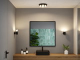 Moderne badeværelse med sort vask, træbordplade og minimalistiske sorte væglamper til stemningsbelysning.