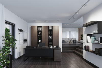 Modernes Büro mit schwarzem Schreibtisch und braunem Holzregal, LED-Deckenstrahler für Arbeitslicht