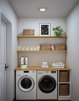 Modern white washing machine and dryer with wooden countertop and wicker baskets in bright laundry room