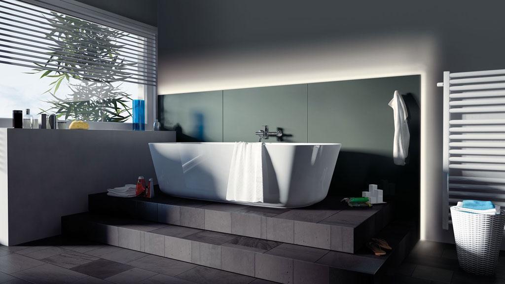 Modern bathroom with freestanding white bathtub on dark platform and indirect wall lighting.