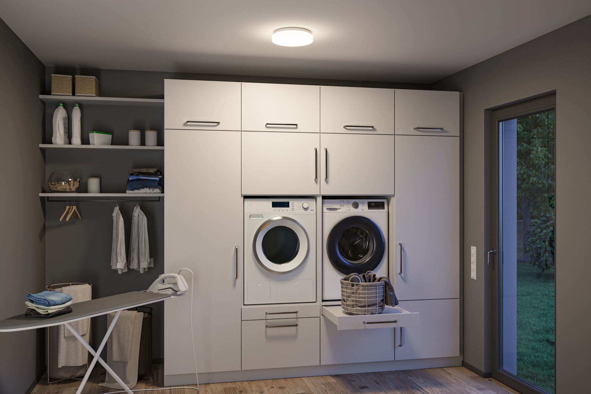 Modern white built-in washer and dryer in gray laundry room with ironing board and laundry basket