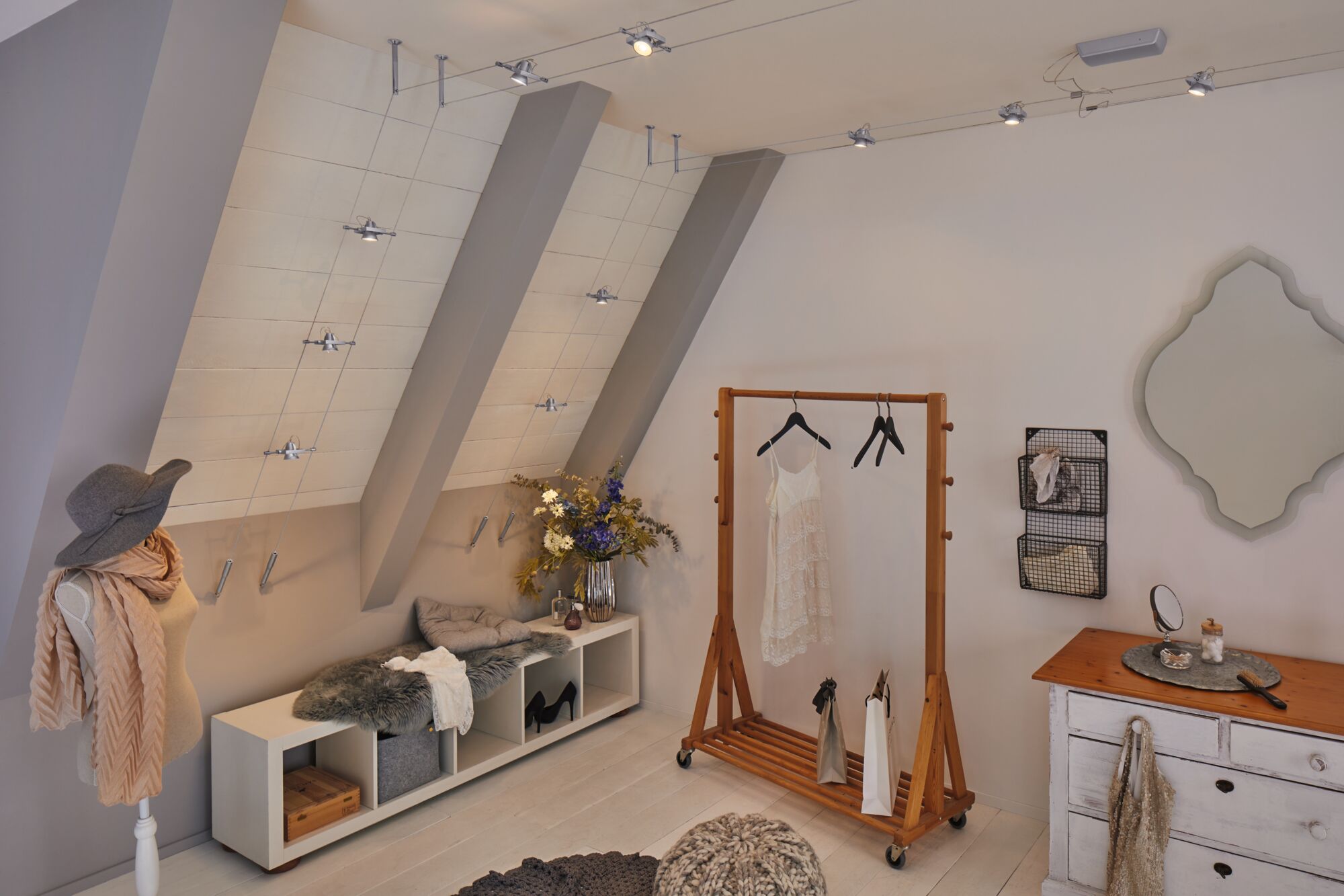 Moderne kleedkamer met houten kledingrek, witte kanten jurk en dimbare LED-kabelspots aan het plafond