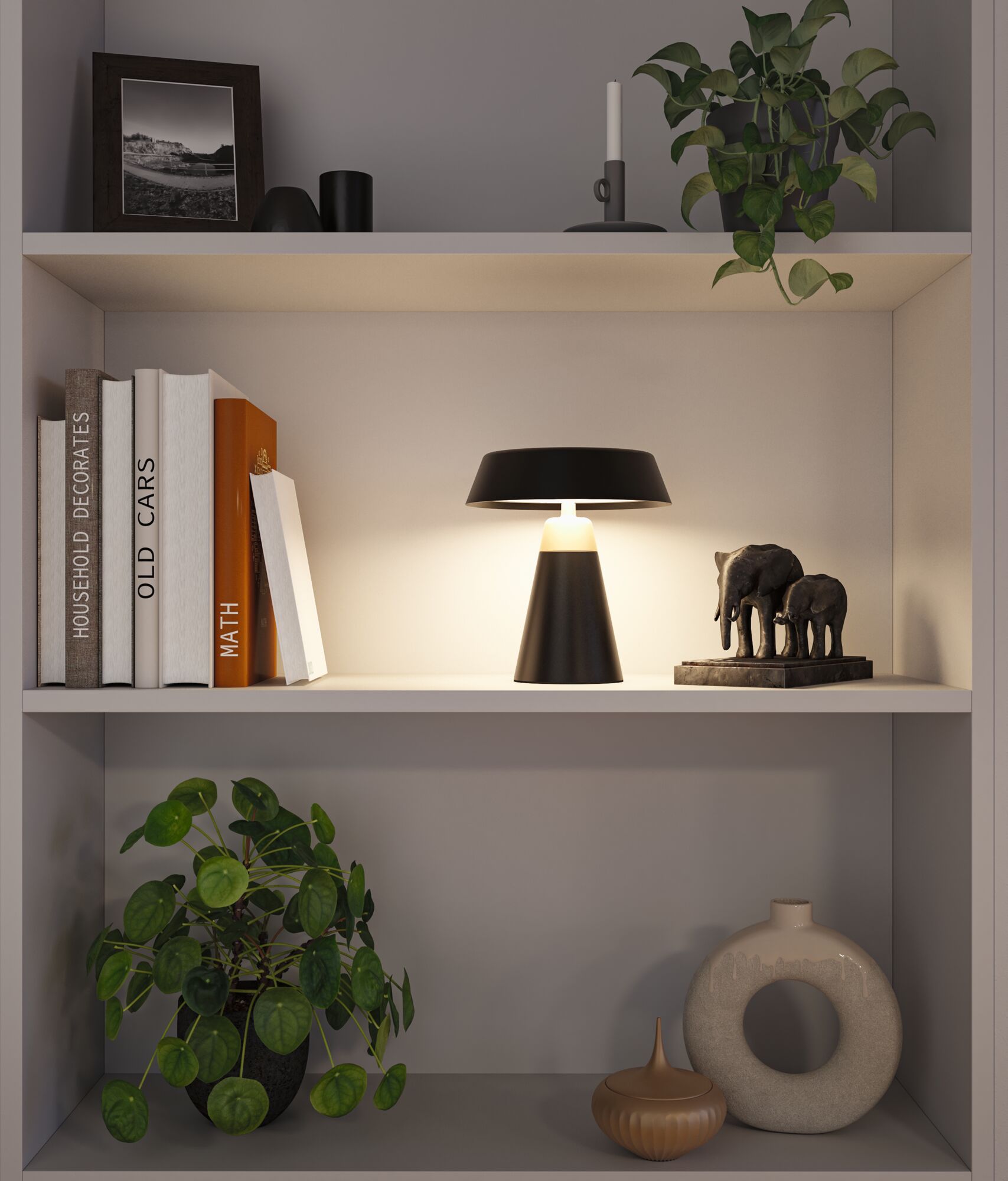 Schwarze Tischlampe aus Metall auf Regal mit Büchern, Pflanzen und Elefantenfigur für Wohnraumbeleuchtung