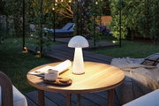 Weiße Pilzlampe aus Kunststoff auf Holztisch im Garten mit Tasse, Keksen und Decke für Outdoor-Beleuchtung