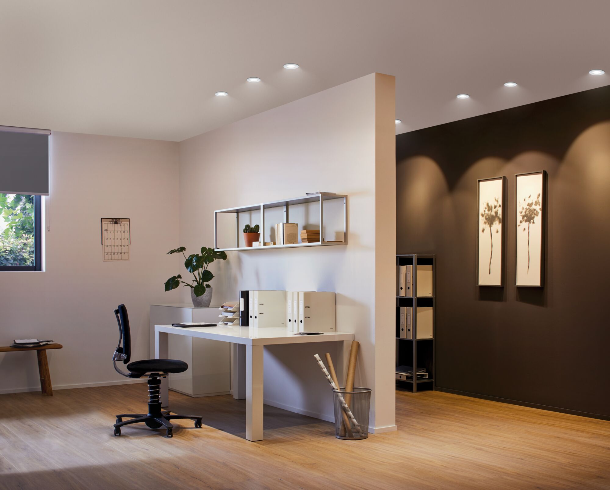 Modern office with white furniture and warm white LED downlights on ceiling for commercial lighting.