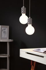 Two hanging LED bulbs with grey metal sockets above white desk with book in modern interior lighting