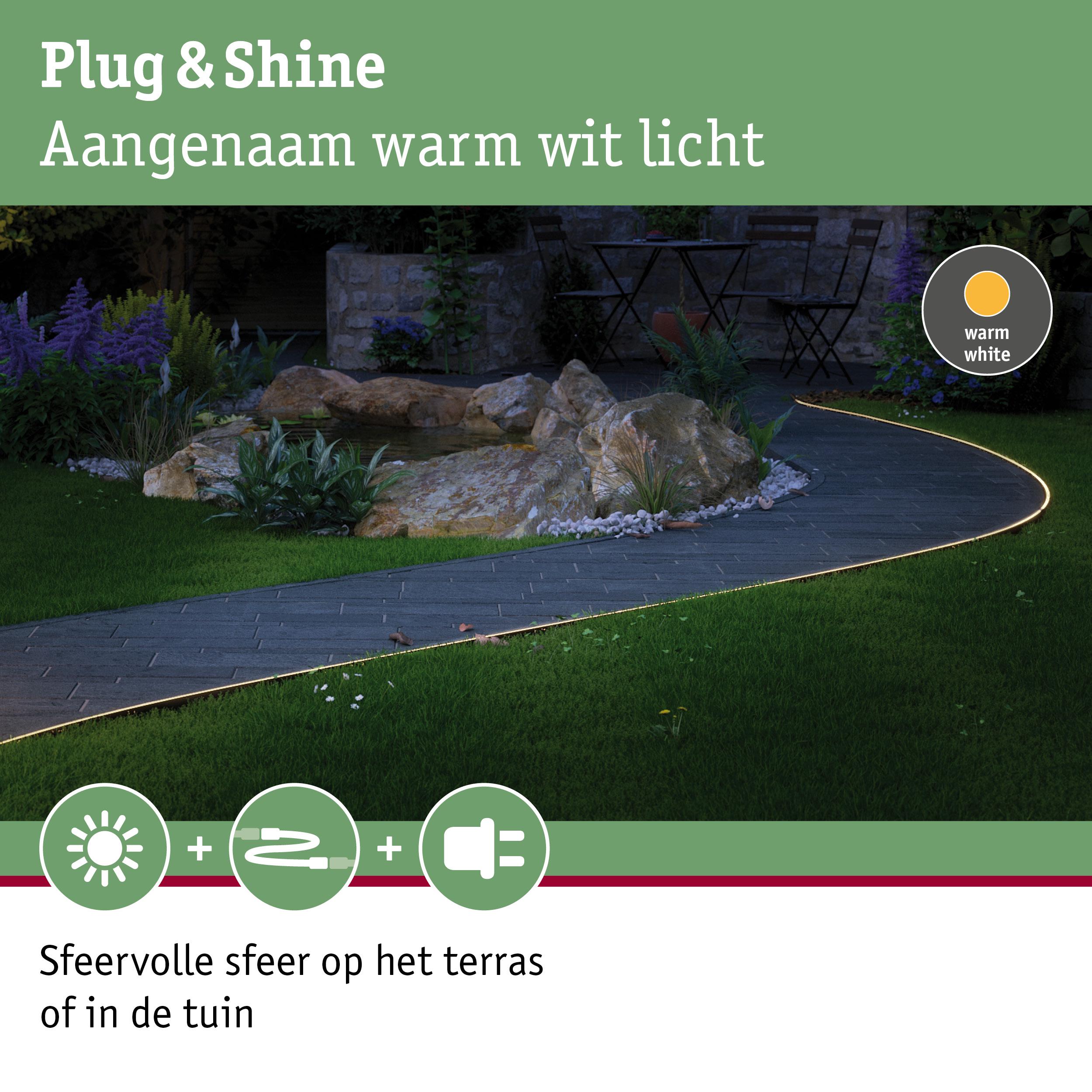 Buitenverlichting met warm wit licht langs tuinpad met stenen en planten