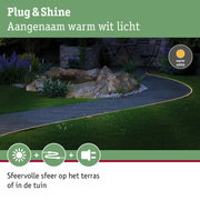 Buitenverlichting met warm wit licht langs tuinpad met stenen en planten