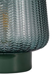 Close-up of green glass lamp with textured pattern and green metal base for home lighting decor
