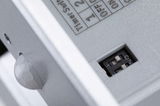 Close-up of grey plastic housing with DIP switch and sensor for light control