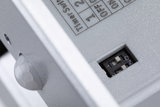 Close-up of grey plastic housing with DIP switch and sensor for light control